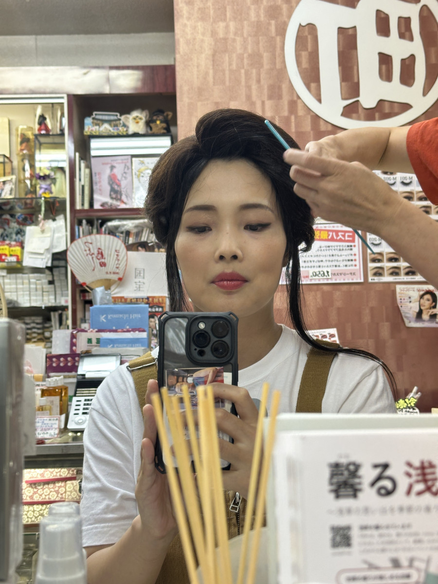 かつらをかぶり前髪をなじませる